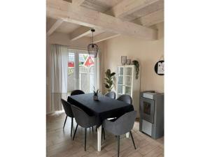 jadalnia z czarnym stołem i krzesłami w obiekcie Alma Comfortable holiday residence w mieście Haselünne