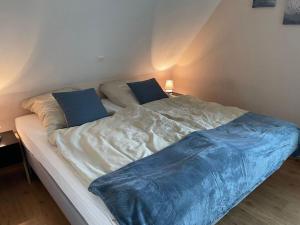 ein Bett mit einer blauen Decke darüber in der Unterkunft Alma Comfortable holiday residence in Haselünne