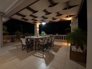 una mesa y sillas en un patio por la noche en Villa Lady Dafni with private heated pool en Maleme