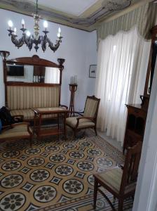 a living room with chairs and a chandelier at Casa Giannina in Palermo