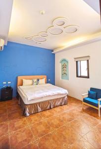 a bedroom with a bed and a blue wall at ShaDao 206 in Eluan