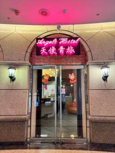 a building with a sign on the entrance to a store at Angels Hostel Taipei Ximen in Taipei