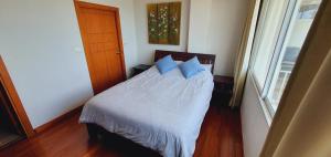 a bedroom with a bed with blue pillows and a window at Seaview Condo B63 in Mae Pim