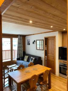 a living room with a table and a couch at Résidence Dryades Hameau De La Vallee D'or - 3 Pièces pour 6 Personnes 14 in Valloire