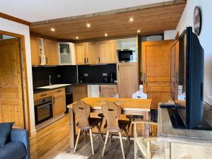 a kitchen with a table and chairs in a room at Résidence Dryades Hameau De La Vallee D'or - 3 Pièces pour 6 Personnes 14 in Valloire