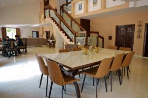 a dining room with a table and chairs and a staircase at Bela exotica in Mahabaleshwar