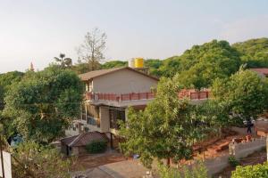 a house in the middle of some trees at Bela exotica in Mahabaleshwar