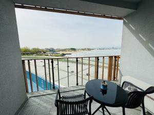 einen Balkon mit einem Tisch und Stühlen sowie Blick auf das Wasser in der Unterkunft PARADISO B 208 Private Sea View Studio NESSEBAR in Nessebar