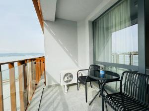einen Balkon mit einem Tisch und Stühlen sowie einem Fenster in der Unterkunft PARADISO B 208 Private Sea View Studio NESSEBAR in Nessebar