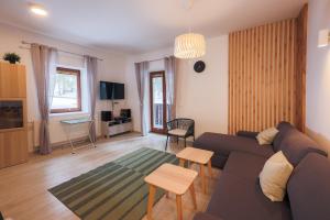 a living room with a couch and a table at Apartment Medved Pokljuka in Zgornje Gorje