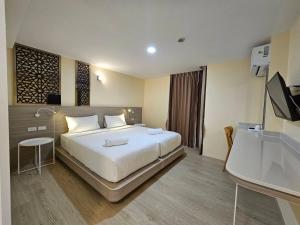 una camera d'albergo con letto e TV di วัน บัดเจท เชียงราย พหลโยธิน One Budget Hotel Chiangrai Phahonyothin a Ban Pa Kluai