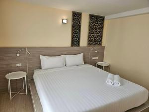 una camera da letto con un grande letto con due asciugamani bianchi di วัน บัดเจท เชียงราย พหลโยธิน One Budget Hotel Chiangrai Phahonyothin a Ban Pa Kluai