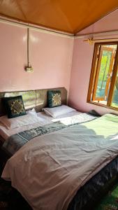 a bedroom with two beds and a window at Al Hayat Guest House in Pahalgām