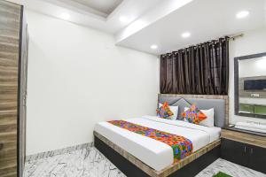 a bedroom with a bed and a flat screen tv at Via SR Royale - Nr Sealdah Station in Kolkata