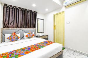 a bedroom with a large bed with colorful pillows at Via SR Royale - Nr Sealdah Station in Kolkata