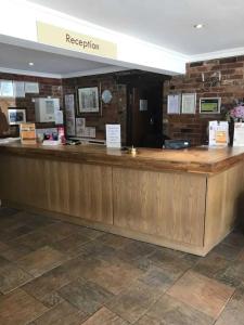 un mostrador de recepción en un restaurante con encimera en OYO The Rivenhall Hotel en Witham