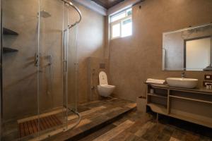 een badkamer met een douche, een toilet en een wastafel bij Singtom Tea Resort in Darjeeling