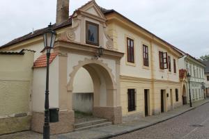 a building with an arch on the side of a street at Penzion U Brány in Kutná Hora