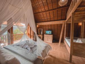 een slaapkamer met een bed met klamboe bij Rural Atmosphere at Bali Coconut House in Delodsema Village in Penginyahan