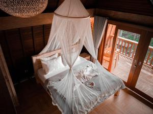 een slaapkamer met een bed met een klamboe bij Rural Atmosphere at Bali Coconut House in Delodsema Village in Penginyahan
