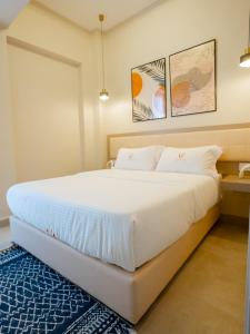 a bedroom with a large white bed with a blue rug at Zarafa Suites in Nairobi