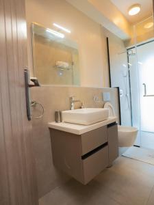 a bathroom with a sink and a toilet and a mirror at Zarafa Suites in Nairobi