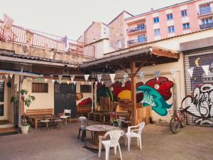 um pátio com mesas e cadeiras em frente a um edifício em Le Flâneur Guesthouse em Lyon