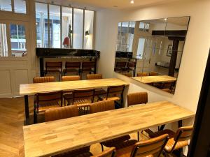 un restaurant avec des tables et des chaises en bois ainsi qu'un miroir dans l'établissement Hotel du Dragon, à Paris