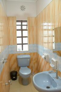 y baño con aseo y lavamanos. en Effie Homes en Naivasha
