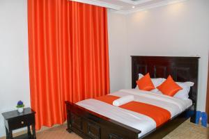 1 dormitorio con 1 cama con cortina naranja en Effie Homes en Naivasha