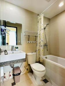 a bathroom with a toilet and a sink and a tub at 8 Newtown Boulevard by Hiverooms in Lapu Lapu City