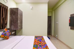 um quarto com uma cama com uma colcha colorida em FabHotel The Sunshine Residency em Calcutá