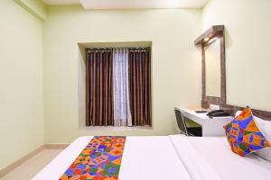 a bedroom with a bed and a desk and a mirror at FabHotel The Sunshine Residency in Kolkata