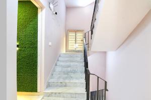 a staircase in a house with a green wall at FabHotel The Sunshine Residency in Kolkata