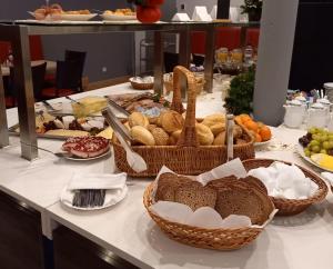 une table recouverte de paniers de pain et d'autres aliments dans l'établissement Hotel garni "Alter Fritz", à Quedlinbourg