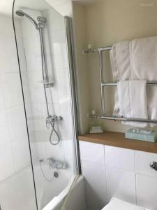 a bathroom with a shower and some towels at OYO The Rivenhall Hotel in Witham