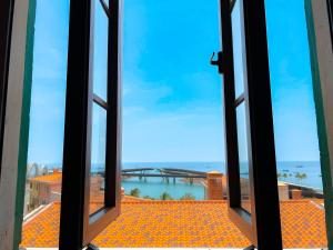 フーコックにあるSunset Hotel Phu Quoc - welcome to a mixing world of friendsの開いた窓から海の景色を望めます。