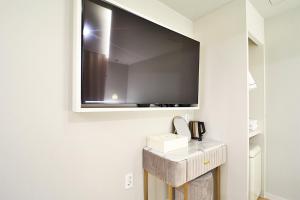 a flat screen tv on a wall in a room at Den Basta Hotel Hadan in Busan