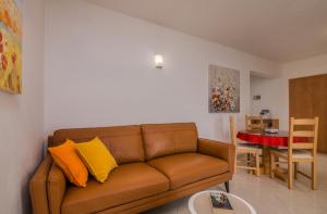 sala de estar con sofá marrón y mesa en Apartments Kvarner 2 en Malinska