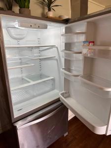 an empty refrigerator with its door open in a kitchen at North Shore of Maui - 2bd-2bath in Paia