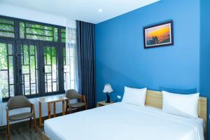 um quarto com 2 camas, uma mesa e cadeiras em BLUE SEA Motel em Thăng Bình