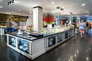 a buffet line in a restaurant with people walking around at Royal Hotel Saigon in Ho Chi Minh City