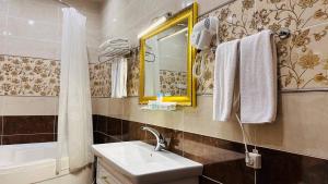 La salle de bains est pourvue d'un lavabo et d'un miroir. dans l'établissement Garden Plaza Bukhara, à Boukhara