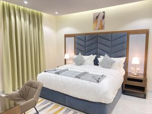 1 dormitorio con 1 cama grande y 1 silla en أوفاز للشقق المخدومة en Riad