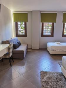 sala de estar con 2 camas y sofá en Z Inn Ioannina, en Ioannina