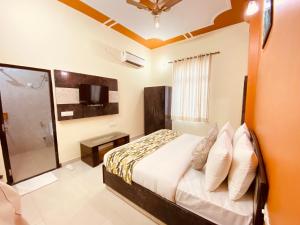 um quarto com uma cama, uma televisão e uma casa de banho em The Tiger Heritage em Sawai Madhopur