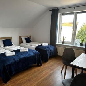 a room with two beds and a table and a window at Pokoje Gościnne Nad Morzem in Łeba