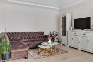 a living room with a brown couch and a table at Tower View Apartment in Vilnius