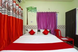 a bedroom with a large bed with red curtains at Goroomgo Hotel Beach Heaven Puri Near Golden Sea Beach & Swargadwar in Puri
