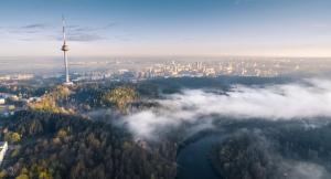an aerial view of a city with a tower in the clouds at Tower View Apartment in Vilnius